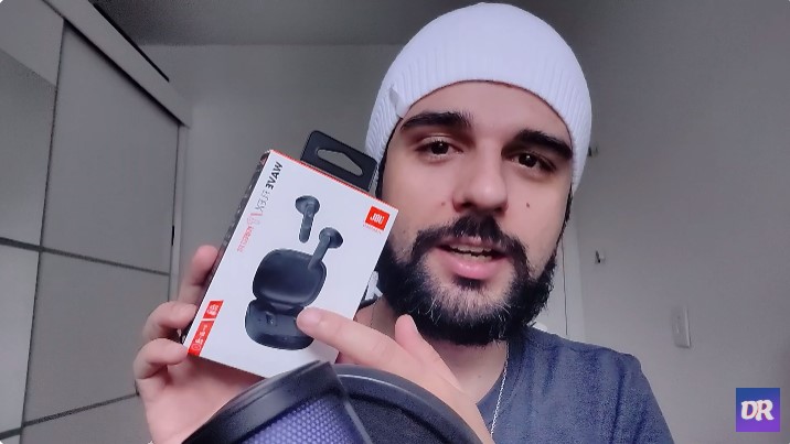Frame do vídeo mostrando o fone JBL Wave Flex na case de carregamento